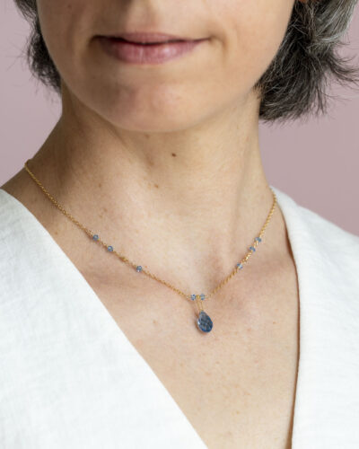 collier or laminé et goutte de cristal bleu